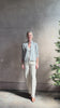 Mature woman reviewing comfortable stone grey cashmere linen GUEST IN RESIDENCE Stealth long sleeve crop Cardigan with single hook and eye front closure crafted in a neutral stone grey