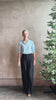 Mature woman wearing Jess Blouse from Trovata rendered in the light blur and crafted from cotton poplin with peter pan collar, half sleeves, intricate pitucking and button front