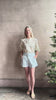 Mature woman reviewing luxurious tailored Emiko Blouse from Veronica Beard a women's designer blouse rendered in a cream  ground adorned with a delicate prairie floral print and crafted from a cotton and silk blend with long sleeves, button front and round mandarin collar.