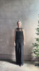 Mature model reviewing luxury Italian designer Forte Forte black wide-leg pull on pants with satin tuxedo side stripe and bottom slit