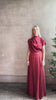 Mature woman reviewing Wish You Would blouse from TWP rendered in a rich currant red and crafted from a luxurious silk blend with a mock neck,  asymetrical design and draping short sleeves shoulder button closure