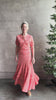 Mature woman reviewing the romantic Abriana Eyelet Knit Cardigan from Ulla Johnson rendered in a luminous coral hue and crafted from luxury knit with round neck, button front and short sleeves
