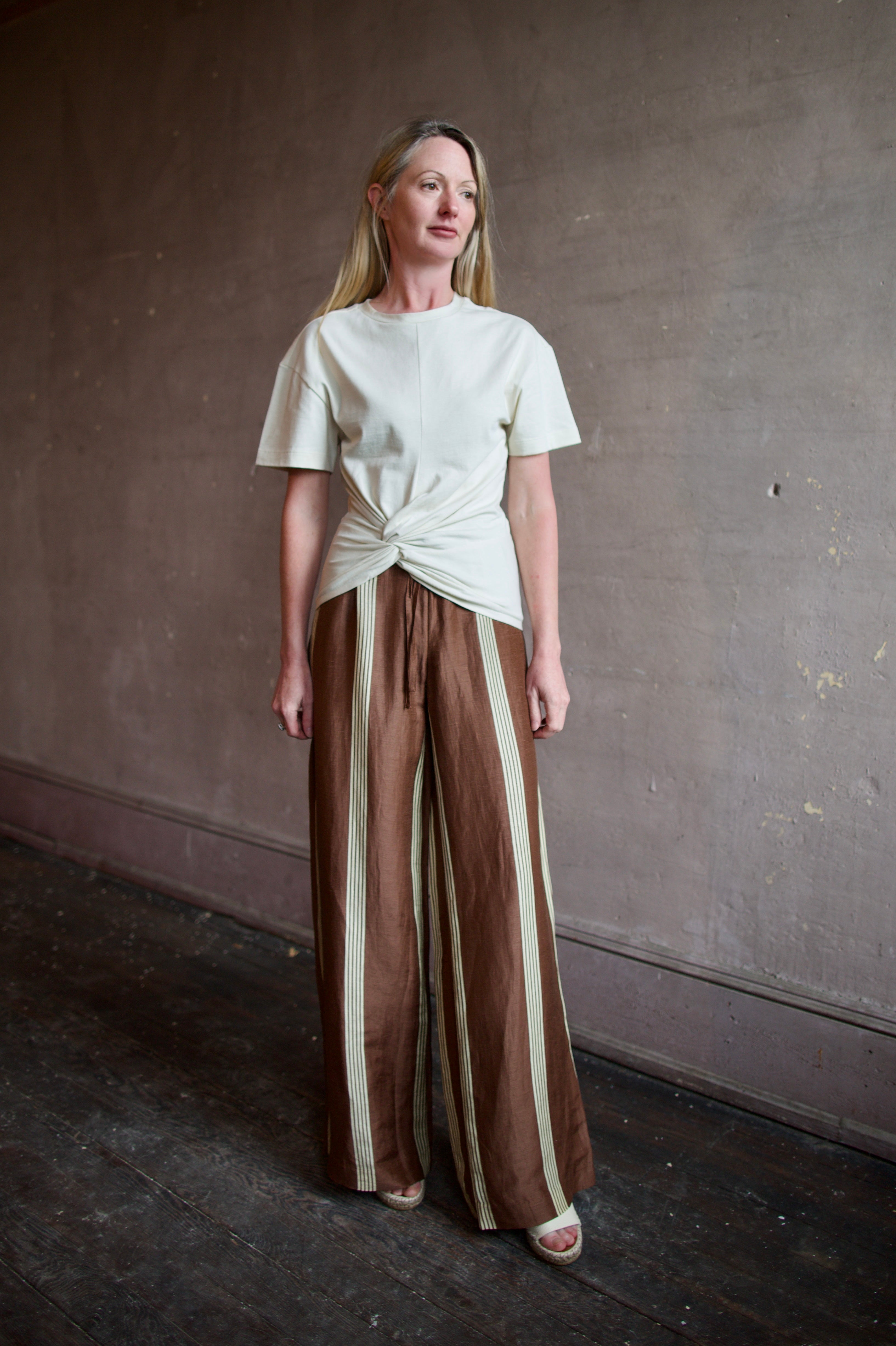 Image of a model wearing designer Rag and Bone Mica Ivory Tee shirt and the Olivia brown Linen Pants