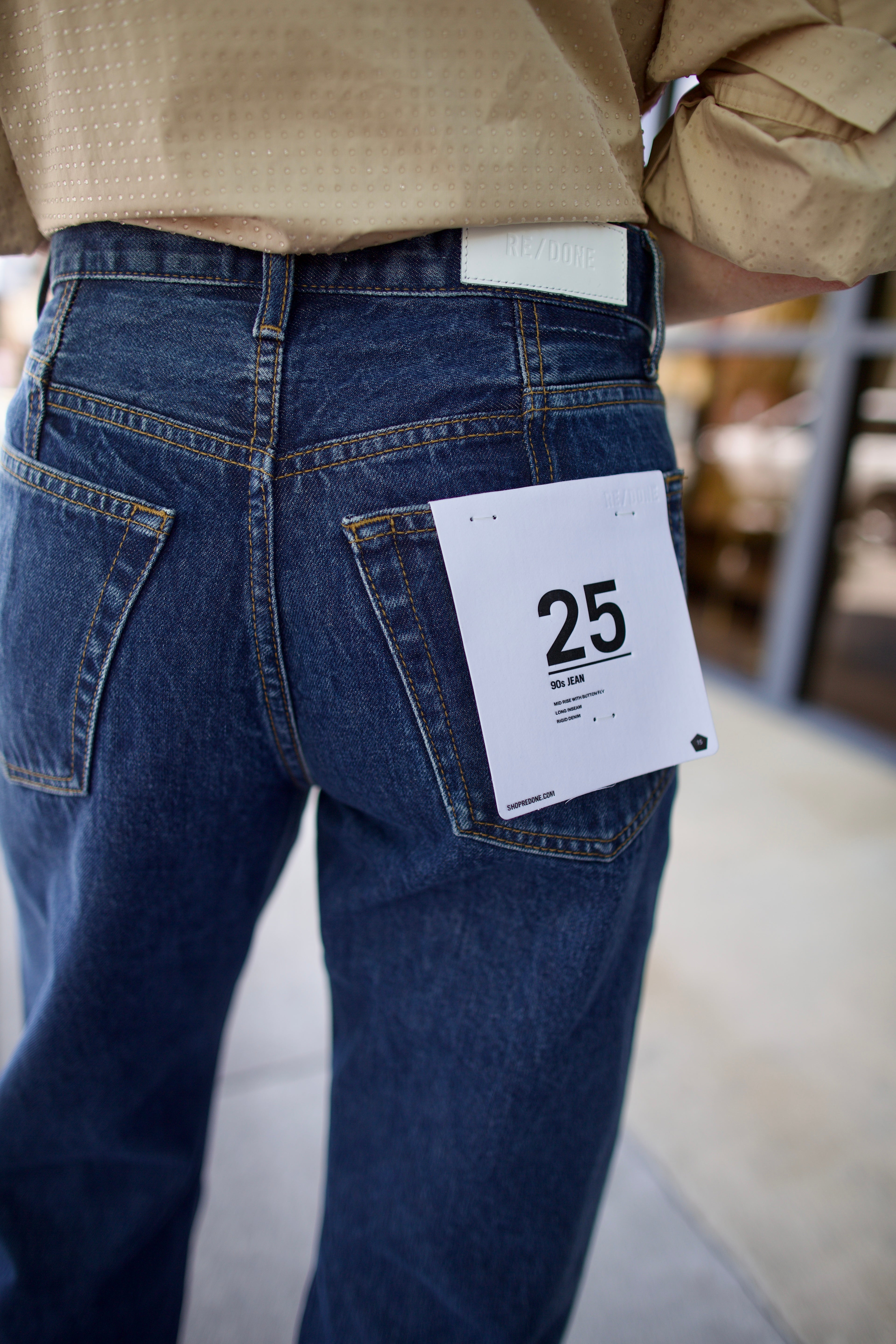 Model wearing Re/Done 90s loose blue jeans in 100% cotton rigid denim with intricate back seam detail