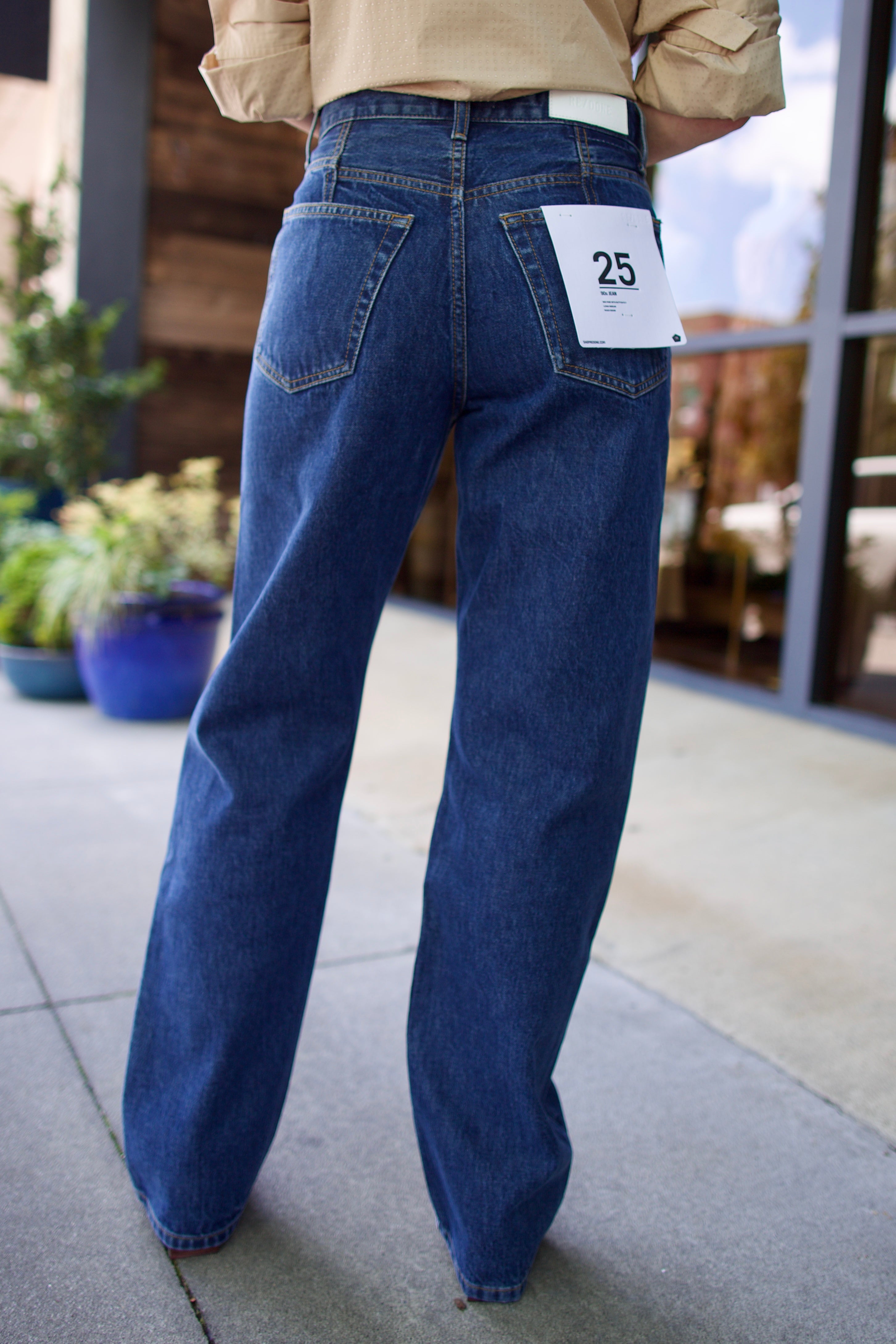 Model wearing Re/Done 90s loose blue jeans in 100% cotton rigid denim with straight leg and rustic indigo wash with no distressing