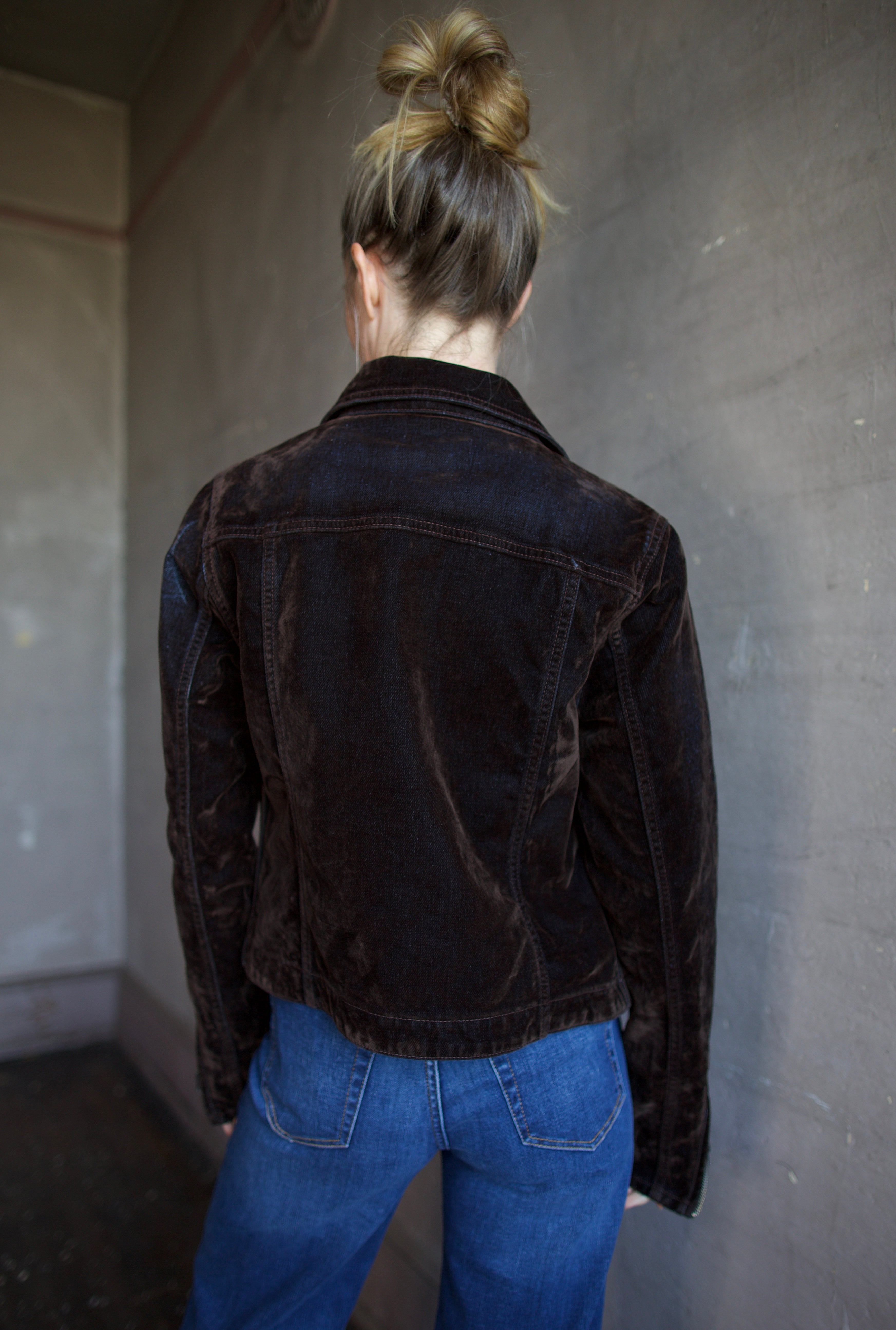 Image of the back of a woman wearing the Re/Done slim jacket and Re/Done 70's ultra high rise jeans