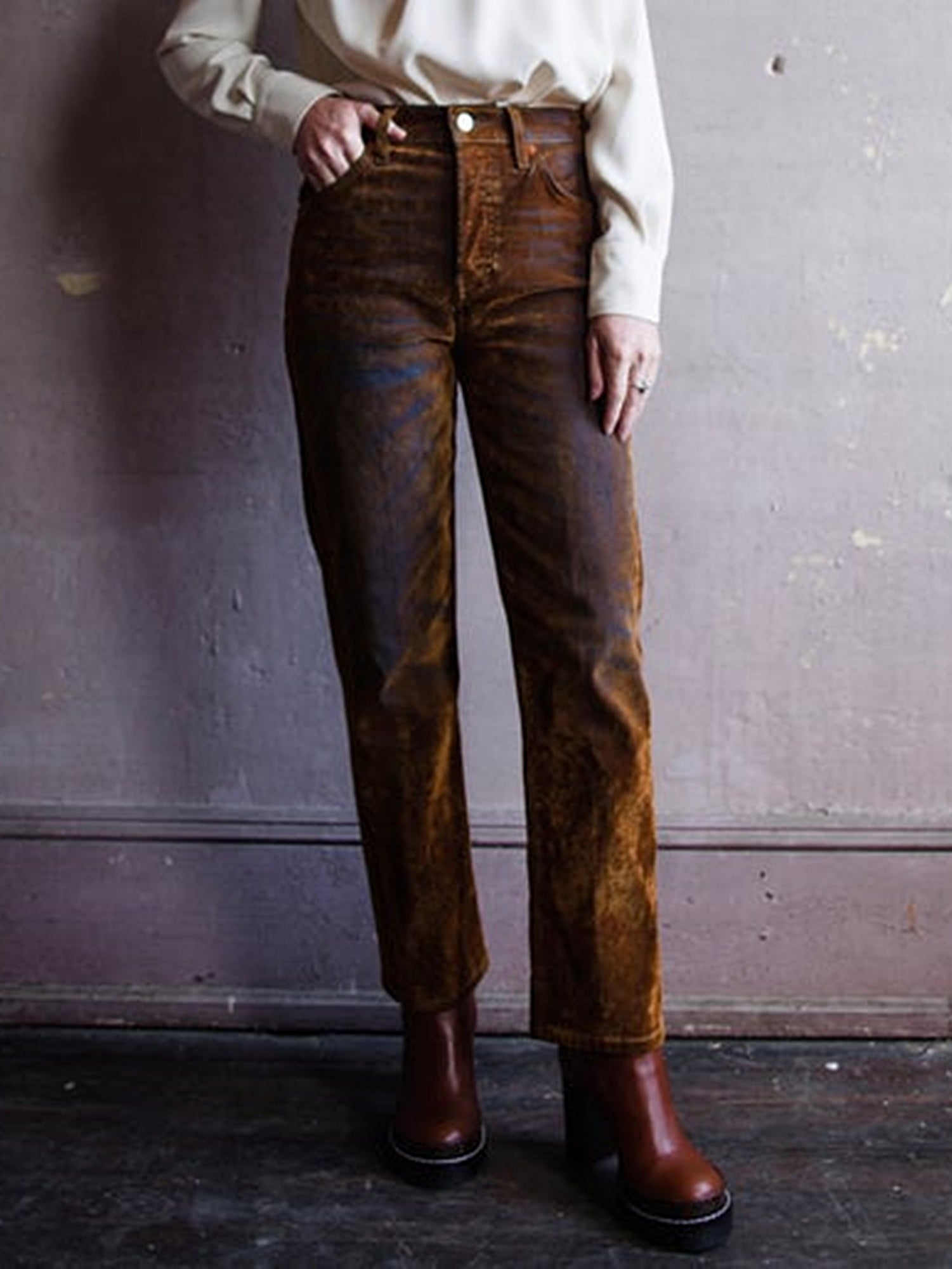 Image featuring a woman wearing the velvet jeans by Re/Done with a high-rise, straight leg, and cropped inseam in amber flocked velvet denim.