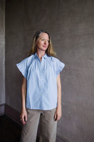 Image of a woman wearing the Marianne B top by Trovata with a button front, ruffle sleeves and boxy fit.