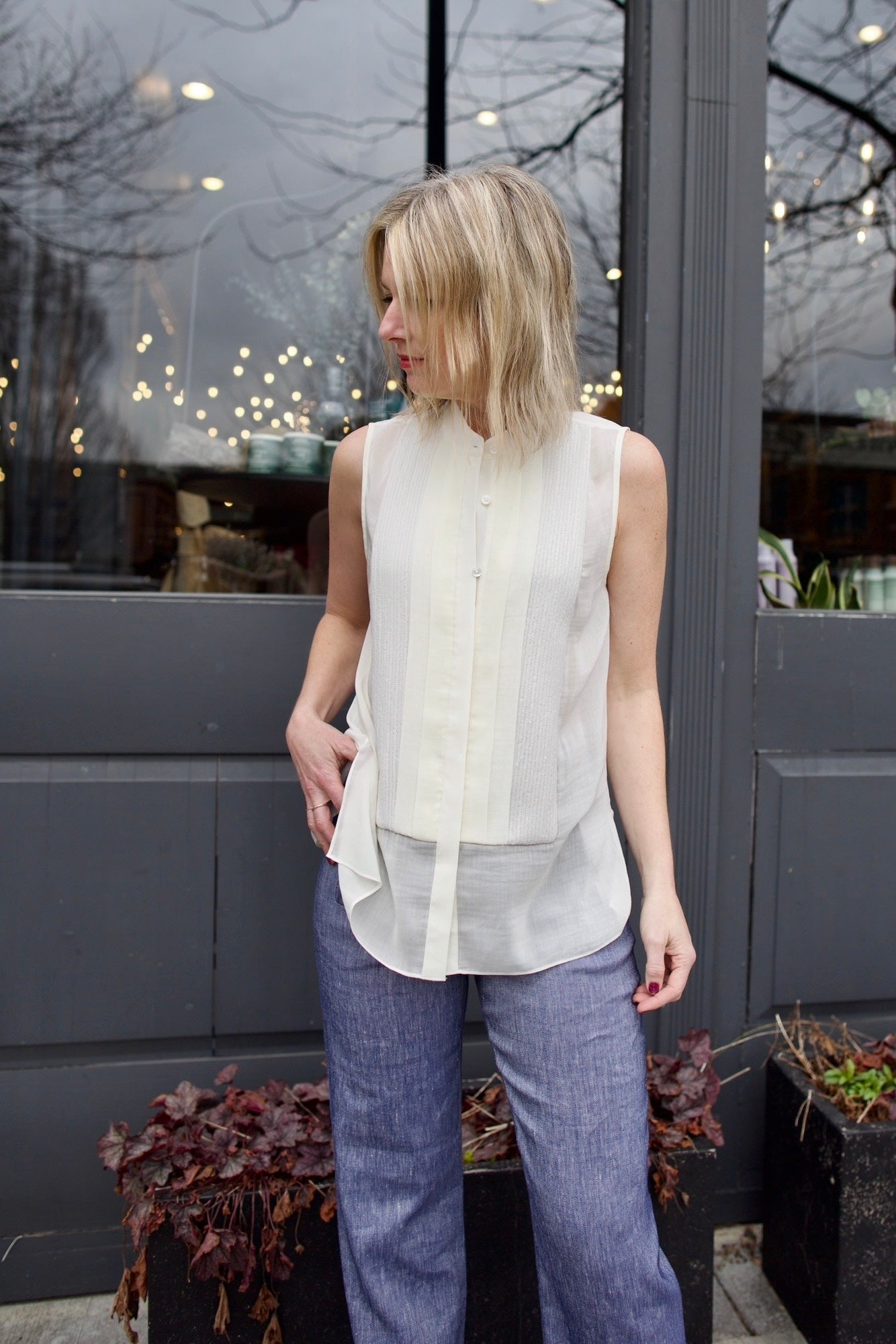 Mature woman wearing luxury brand TWP Adele top with button placket sequin detailing and tux-inspired design in premium silk cotton blend