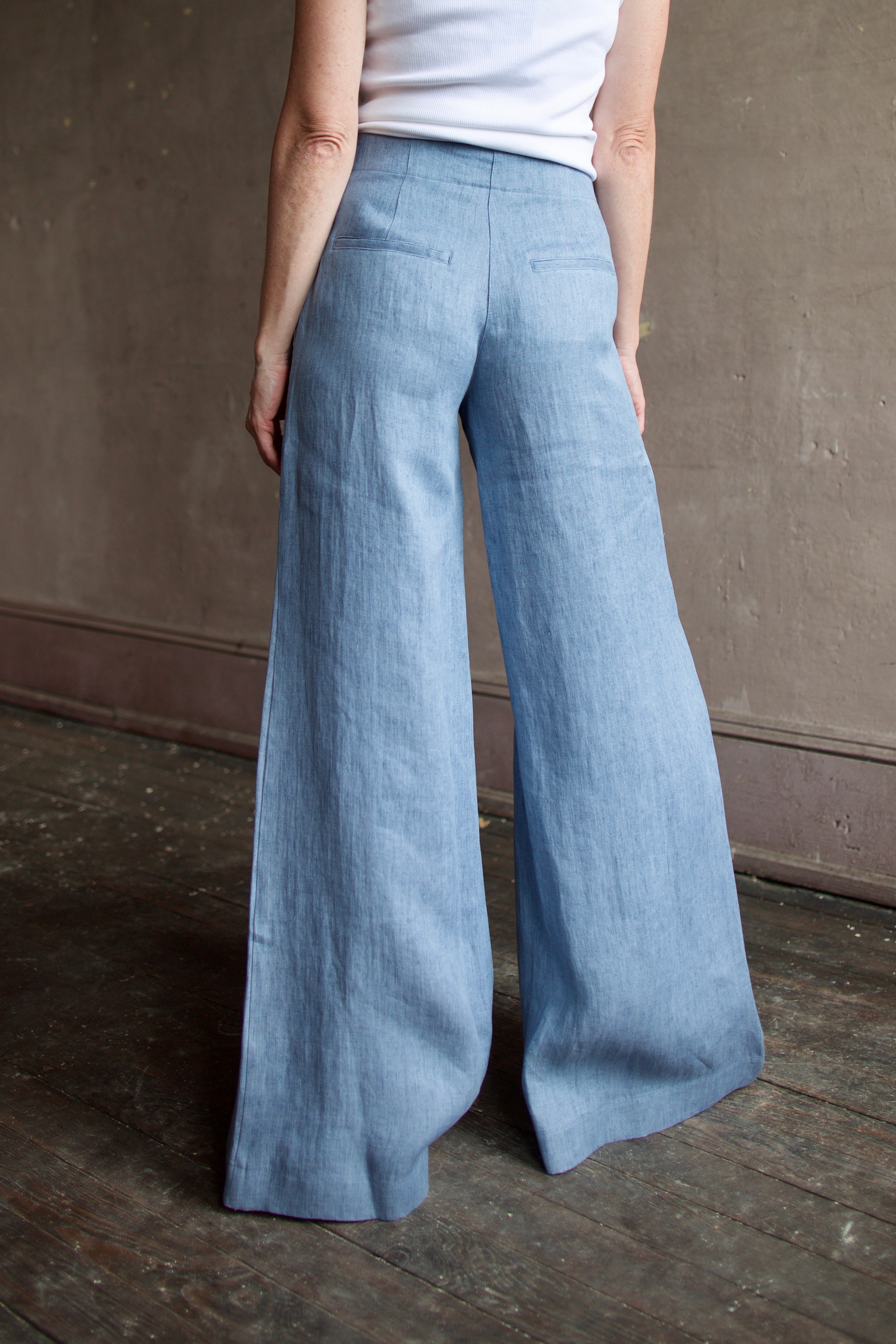 Model wearing luxury brand TWP Demie High Rise wide leg indigo hemp Pants offers timeless  refinement and expert craftsmanship