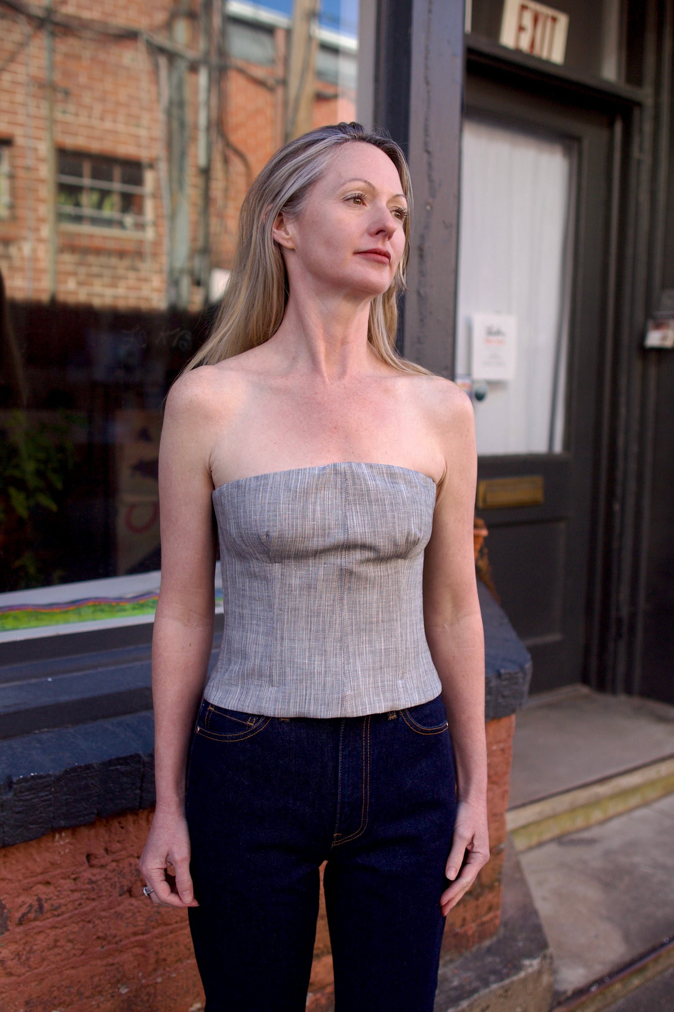 Mature woman wearing luxury brand TWP Jillian cotton-wool bustier in heather grey with bust darts and zip closure perfect for elevated layering 