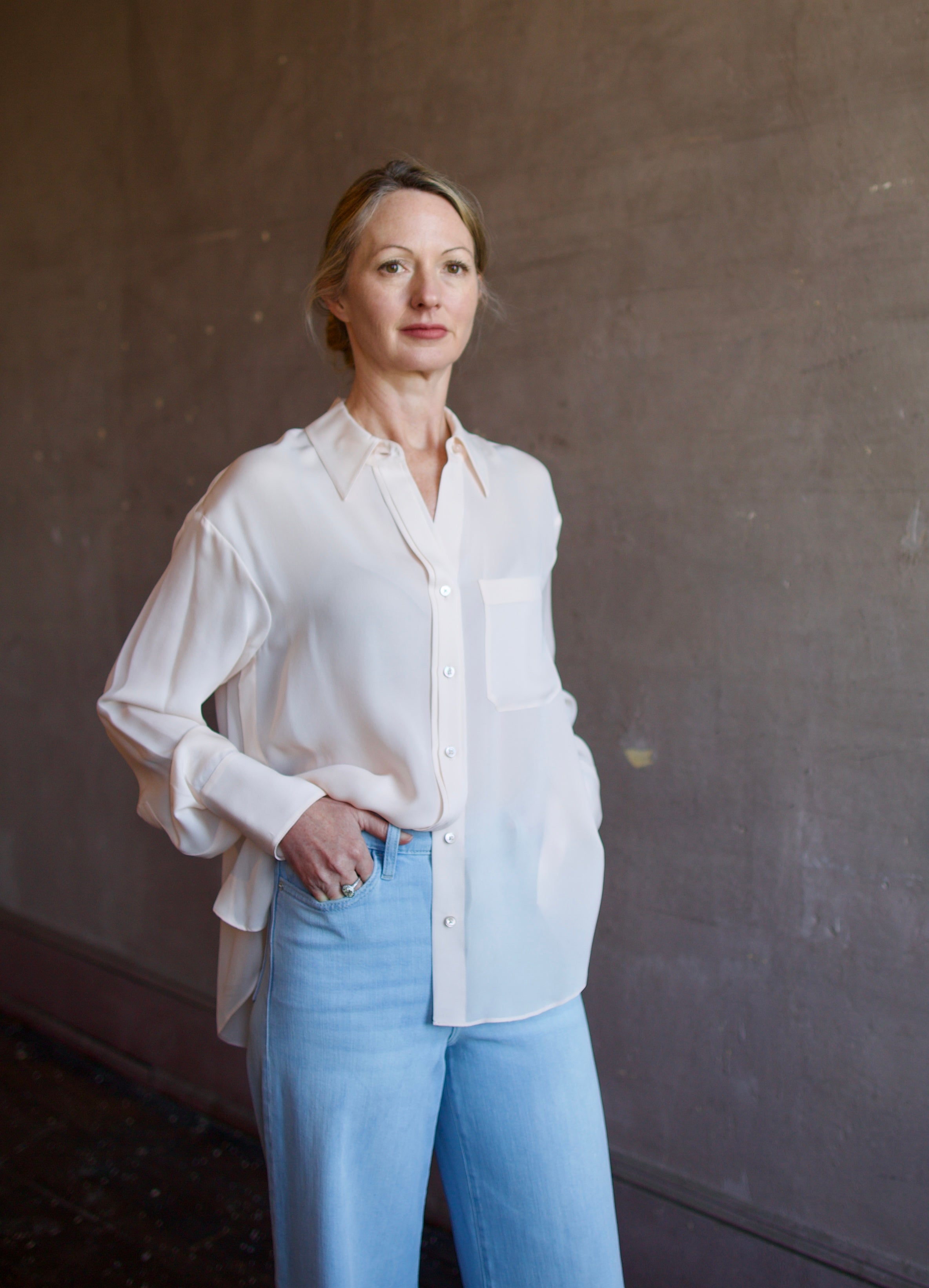 Mature woman wearing luxury women's pink sheer silk Joey blouse by TWP with front pocket, delivering sophisticated elegance