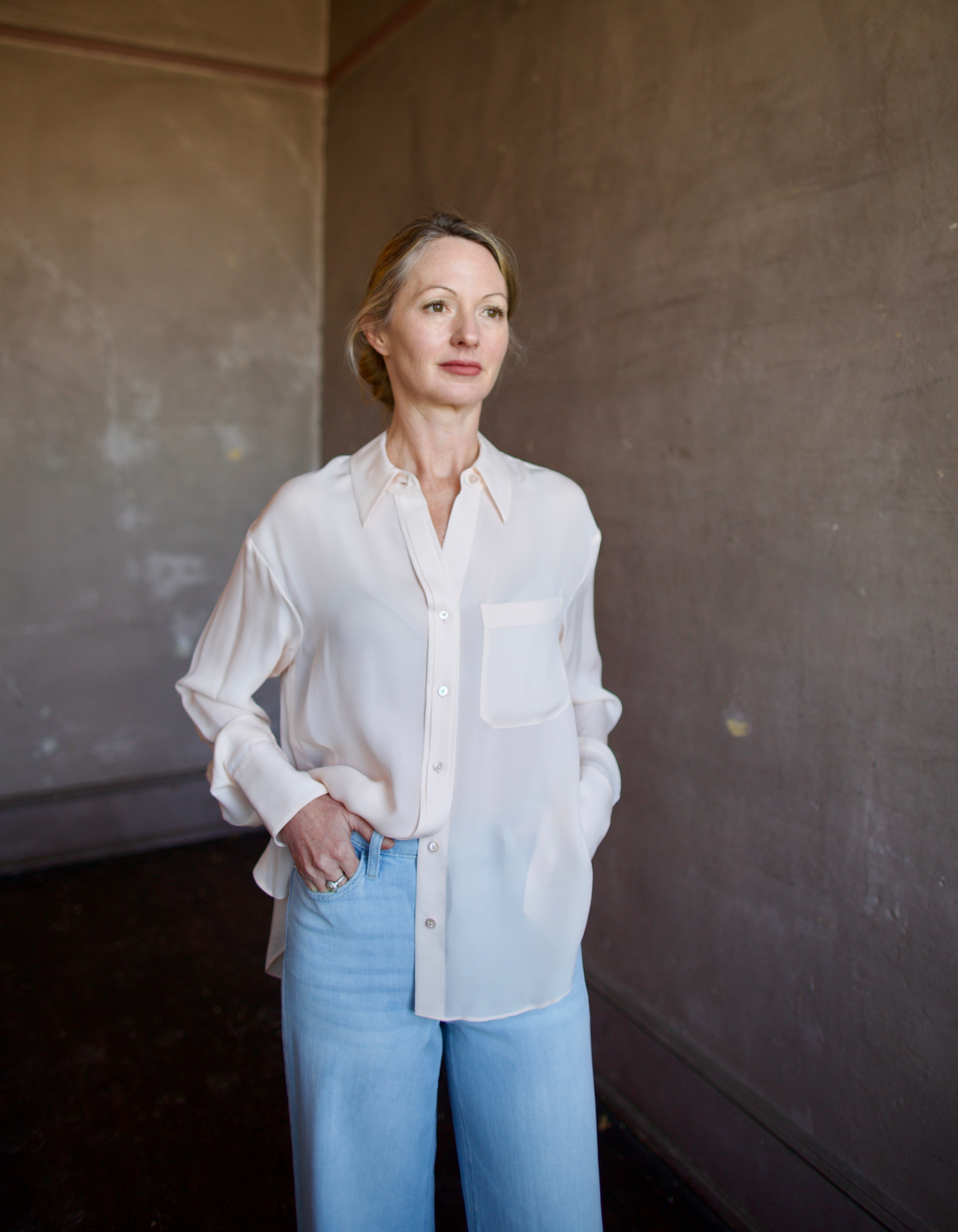 Mature woman wearing luxury women's pink sheer silk Joey blouse by TWP with front pocket, delivering sophisticated elegance