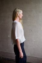 Side view Image of a woman wearing the TWP Knit Tee with Pointelle in Ivory