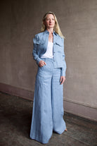 Image of a woman wearing the TWP New Carter Button Up Top and Demie High Rise Flare Pants