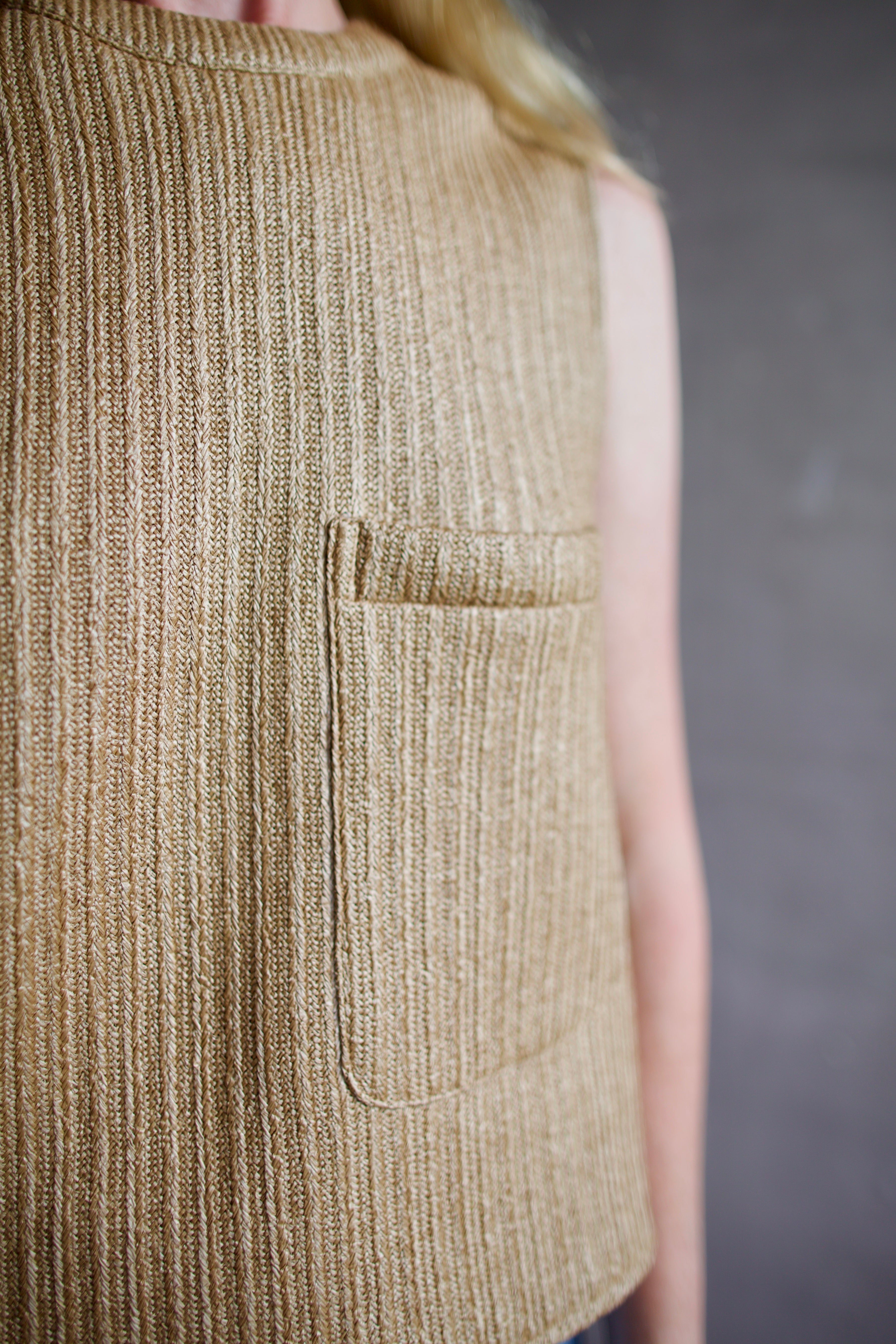 Mature woman wearing the TWP Cropped top in a raffia textile with crew neck sleeveless front pocket