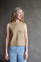 Mature woman wearing the TWP top in a raffia textile with crew neck sleeveless front pocket