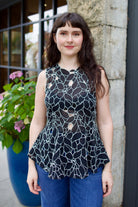 Model wearing the Ulla Johnson Ali Sleeveless black cotton peplum top with contrast white embroidery for ultimate feminine sophistication