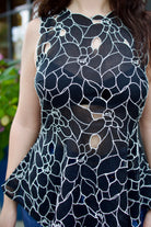 Model wearing the Ulla Johnson Ali Sleeveless black cotton peplum top with contrast white embroidery for ultimate feminine sophistication