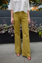 Mature woman wearing luxury designer jeans by Ulla Johnson in Lou cotton rigid full length denim with premium gold buttons and patch pockets in argan colorway