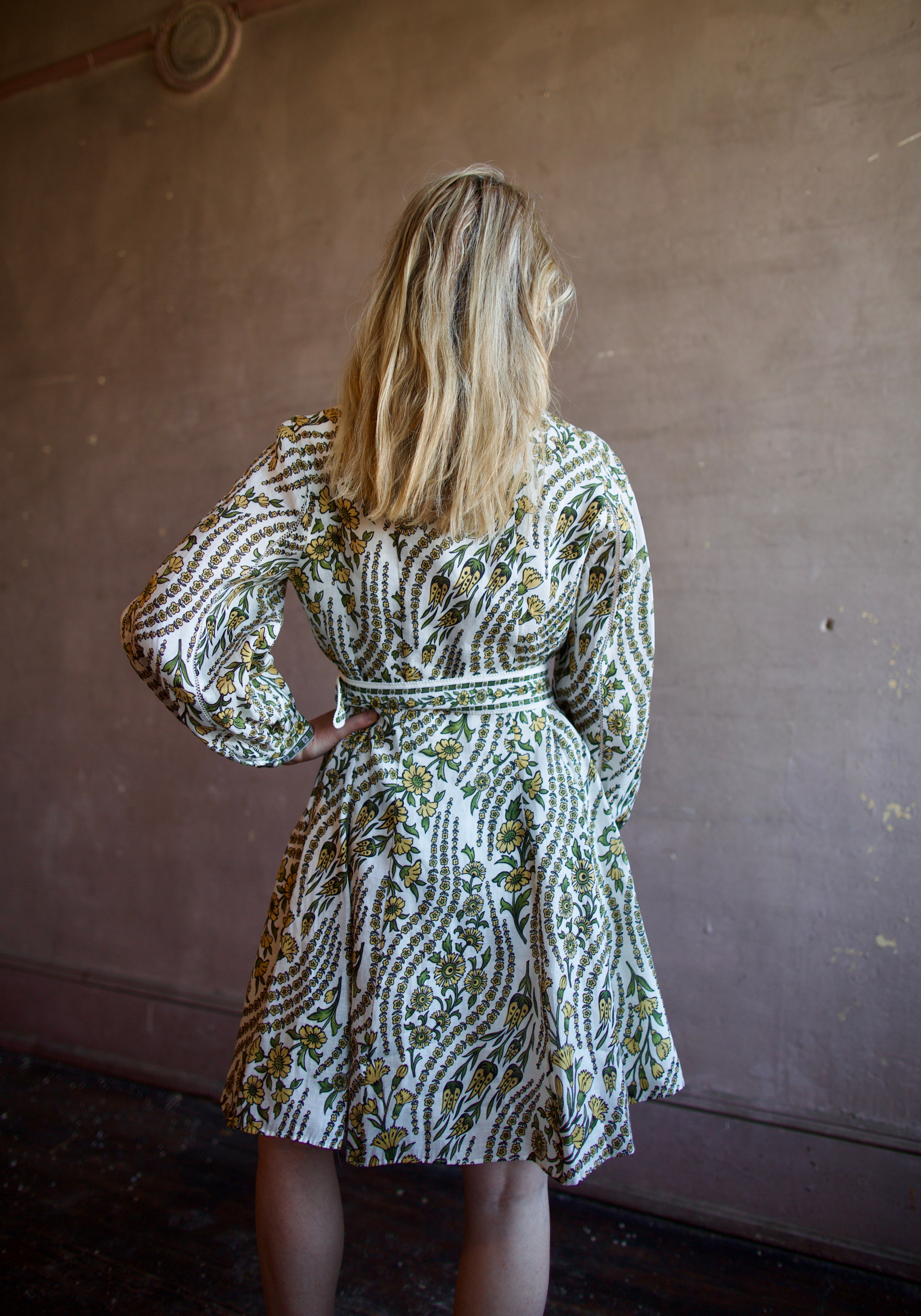 Mature woman wearing luxury women's linen Nolan dress by Veronica Beard featuring button front removable belt long sleeves and knee length skirt